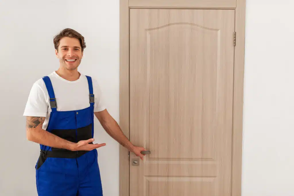 Schlüsseldienst Ramersdorf - a man in overalls standing next to a door